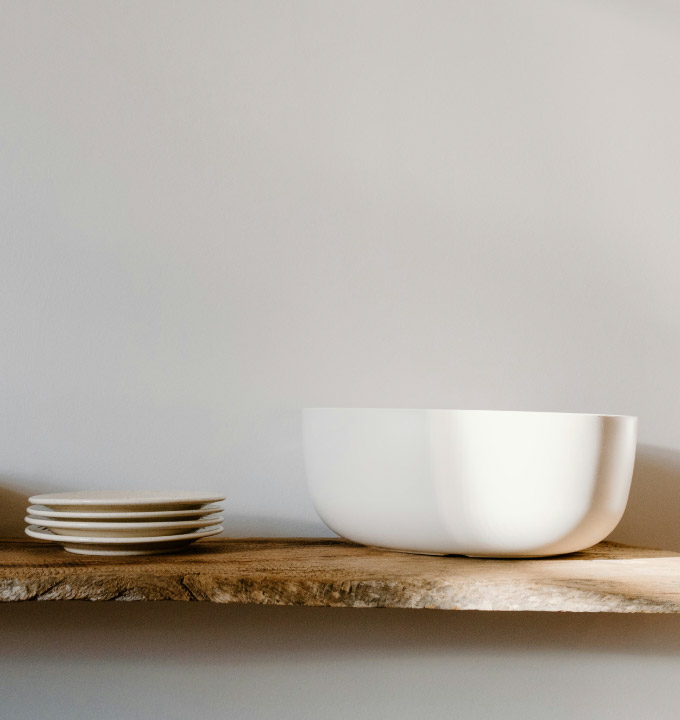Shelf with stacked plates and a large white bowl